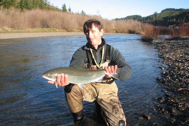 Guide Andrew Harris with a steelhead just a few miles upstream from the ocean.