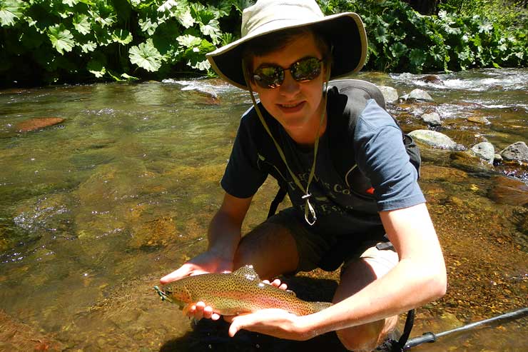 A young angler with a McCloud rainbow that ate a big hopper dry